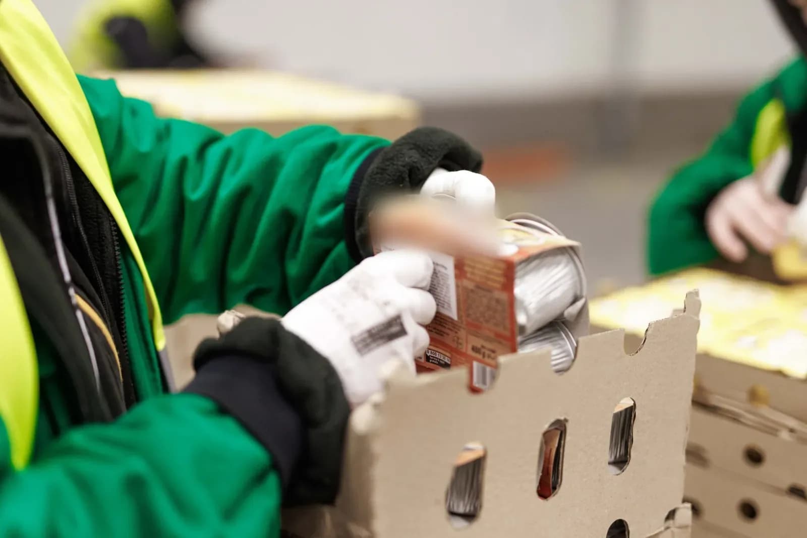 HOPI Logistics worker in gloves repacking goods into cartons during co-packing
